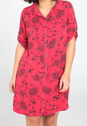 Sukienka z krótkim rękawem na guziki, wykonana z żywej czerwonej tkaniny z czarnym kwiatowym wzorem, z dwoma kieszeniami na piersi i luźnym krojem.