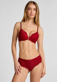 Rotes Spitzen-Dessous-Set mit Push-up-BH, verstellbaren Trägern und dekorativer Satin-Schleife, kombiniert mit passendem Spitzen-Slip.