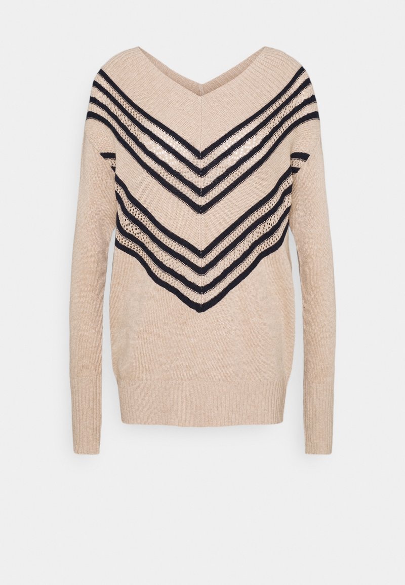 Pull beige en tricot avec manches longues, col en V et rayures chevrons noires avec des détails en maille ajourée à l'avant et sur les manches.