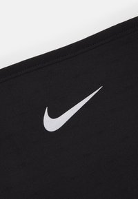 Tessuto atletico nero con una consistenza liscia, caratterizzato da un grande logo Nike argentato sul lato sinistro. Il design è minimalista e elegante.
