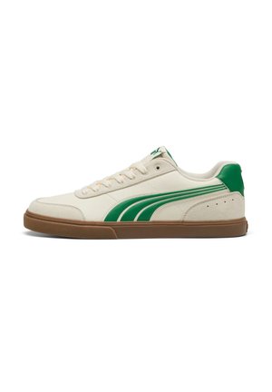 Sneaker bianco basso con striscia verde laterale e tallone, suola in gomma marrone e lacci bianchi.