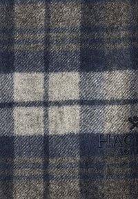 Écharpe en laine avec un motif plaid bleu et gris, agrémentée de nuances de gris clair. Comprend un logo brodé dans le coin inférieur.