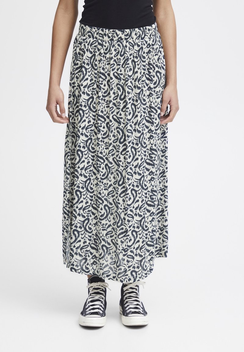 Maxikjol i lätt tyg med en krämfärgad botten och ett marinfärgat paisleymönster, med resår i midjan och en flytande silhuett.