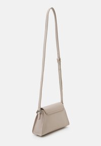 Borsa a tracolla beige con una forma triangolare strutturata, texture liscia, tracolla regolabile e chiusura a patta. Dettagli di design minimalista.
