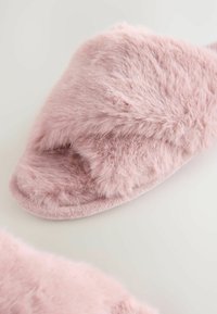 Roze faux fur schuifslipper met een zachte textuur en afgerond ontwerp, voorzien van een brede, fuzzy bovenkant en een gevoerde voetbed.