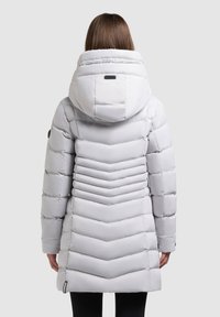 Světlě šedá prošívaná bunda s odnímatelnou kapucí, vodorovným prošíváním a vypasovaným střihem. Na rukávu je nášivka s logem.