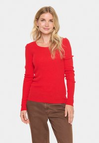 Red ribbed long-sleeve sweater with a round neck. The fabric appears soft with a fitted silhouette and subtle texture.
