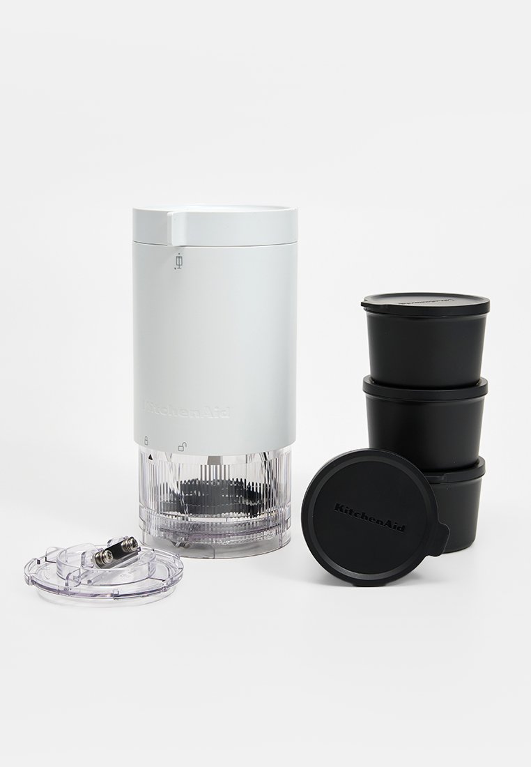 KitchenAid hakker in wit met doorzichtige basis, bevat vier zwarte opbergcontainers met deksels. Heeft een verwijderbare bovenkant en mixblades.