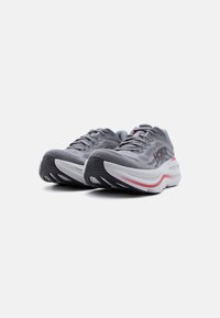 Ζευγάρι γκρι αθλητικά παπούτσια με ροζ λεπτομέρειες, υφασμένες επάνω επιφάνειες, παχιές λευκές σόλες και μαύρες εξωτερικές αντιολισθητικές σόλες σε λευκό φόντο.