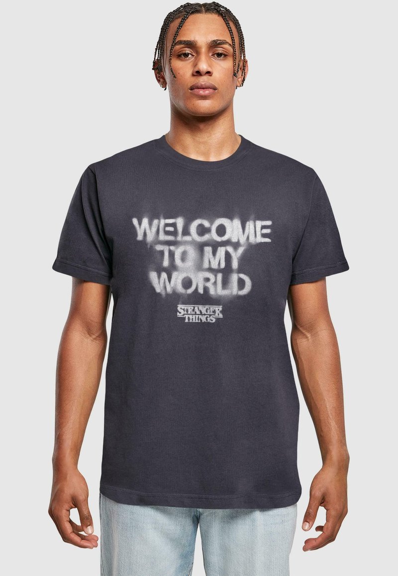 Juodas medvilninis marškinėliai su balta purkštuko spausdinimo užrašu "WELCOME TO MY WORLD" ir "STRANGER THINGS" logotipu apačioje. Trumpomis rankovėmis, apvalia iškirpte.