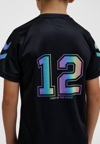 Maillot de sport noir avec un grand numéro « 12 » en dégradé et le texte « ÉCLAIREZ LE MONDE » dans un design frappant et coloré.
