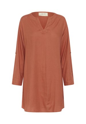 Túnica de color óxido con escote en forma de V, mangas de tres cuartos y corte relajado. Está confeccionada con una tela suave y de textura lisa. Sin patrones ni adornos.