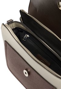 Brązowa i kremowa torebka o fakturowanej powierzchni z srebrnym zamkiem, wyposażona w oddzielną wewnętrzną kieszeń i zamknięcie na magnes z przodu.