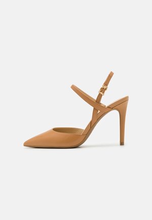 Sandaletti in pelle tan con tacco alto e punta affilata, sottili cinture incrociate e un elegante tacco a spillo. Dettagli in metallo dorato.