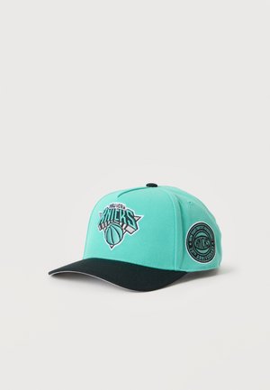 Casquette de baseball turquoise et noire avec le logo des New York Knicks sur le devant et un patch du 70e anniversaire sur le côté.