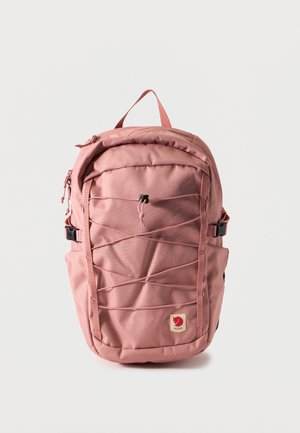 Sac à dos de randonnée rose avec cordon élastique à l'avant, poches latérales, poignée supérieure et patch logo sur fond uni.
