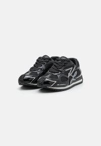 Chaussures de sport noires avec une finition brillante, des panneaux en maille, des lacets et des semelles en caoutchouc texturé. Présente des détails réfléchissants et un logo.