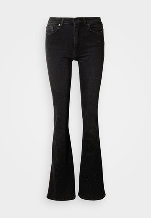 Crne trapez traperice s laganim sjajem zbog šarenih detalja, izrađene od trapera, s klasičnim dizajnom s pet džepova i prednjim zatvaranjem na gumbe.