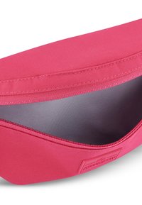 Růžová látková kapsička s hladkým interiérem, zapínáním na zip a texturovaným vnějším povrchem, který má decentní prošívání a značkovou etiketu.