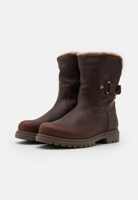 Bottines en cuir marron avec une doublure en fourrure douce, accent de boucle, bout arrondi, semelle robuste et détails de couture.
