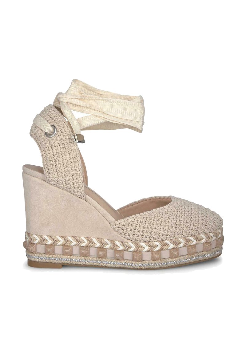 Espadrille compensée beige avec un dessus en textile tissé, un talon en cuir suédé et une bride de cheville en tissu. Présente une semelle en jute tressé.