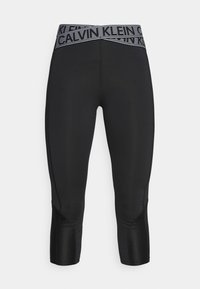Zwarte capri legging met een getextureerde tailleband en een gestreepte "Calvin Klein" logo. Strak, figuurvolgend ontwerp met zijnaht.