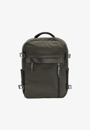 Ciemnozielony plecak wykonany z wytrzymałego materiału; posiada przednią kieszeń na zamek, regulowane paski i metalowe akcenty.