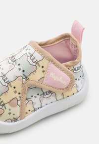 Auduma slip-on kurpes ar kaķu rakstu pasteļtoņos, maigi bēšas akcenti un rozā cilpa ar "Playshoe" izspiestu uz sāna.