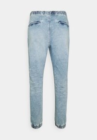 Vaaleansiniset farkkijoggerit, joissa on joustava vyötärö, kahdella takataskulla ja kuvioitu lahje nilkoissa.