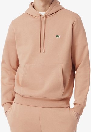 Hellrosa Hoodie mit vorderer Kängurutasche und Kordelzug, mit kleinem grünem Krokodil-Logo auf der linken Brust.