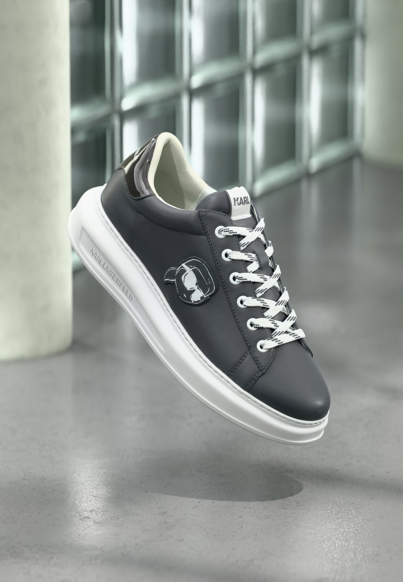 Sneaker med mørk marineblå skinnoverdel, hvit såle og kontrasterende lisser. Merkbar Karl Lagerfeld-logo på siden og teksturerte bakre detaljer.