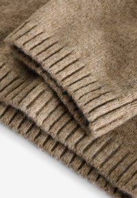 Tissu en laine marron avec un tricot texturé, présentant des côtes verticales. Le tissu semble doux et chaud, plié pour montrer les couches.