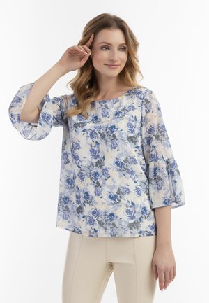 Blomsterbluse med blå og grå roser på en lys baggrund, med trekvart lange klokkeærmer og rund halsudskæring.