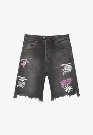 Černé denim šortky s distressed lemem, zdobené bílými a růžovými potisky, včetně textu a tvarů. Třepené okraje dodávají texturu.