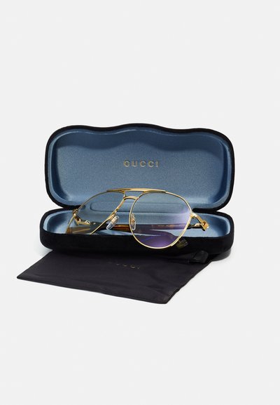 Gold aviator sunglasses with a gradient purple lens, housed in a black and blue hard case. Includes a black microfiber pouch.