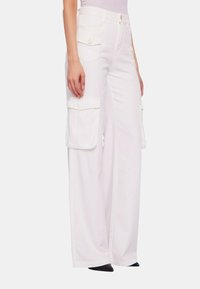 Pantaloni cargo a gamba larga in denim bianco, con due tasche laterali e hardware in tono oro. Vestibilità sartoriale con una sottile texture.