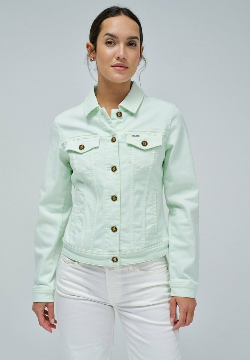 Chaqueta de mezclilla verde menta clara con un diseño ajustado, grandes bolsillos frontales y cierres de botón en tono dorado. Textura suave y detalle en el collar.