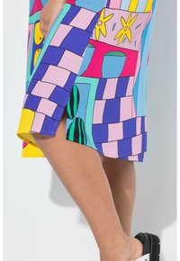 Vestido colorido con diseño de patchwork en tonos vibrantes de azul, amarillo, rosa y verde, con una abertura lateral. Tela texturizada.