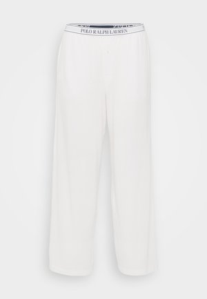 Valkoiset pyjamat, joissa on löysä istuvuus, ja joissa on merkitty vyötärönauha ja nappisuljenta. Valmistettu pehmeästä kankaasta, jossa on sileä tekstuuri.