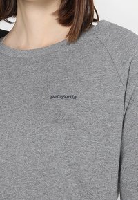 Grauer Sweatshirt mit Rundhalsausschnitt, Raglanärmel und kleinem Logo auf der Brust. Hergestellt aus strukturiertem Stoff mit weichem Aussehen.