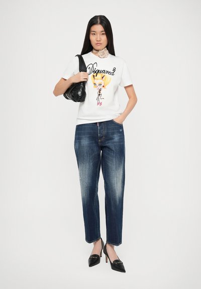 T-shirt bianca con grafica colorata, abbinata a jeans dritti blu scuro e décolleté nere a punta. Inclusa borsa nera.
