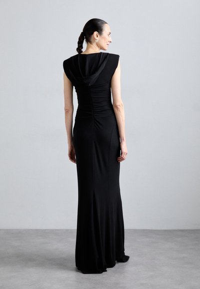 Vestido de noche negro, ajustado, con un escote capuchino, detalle fruncido en la parte trasera y una sutil abertura lateral en el dobladillo. Tejido suave y elástico.