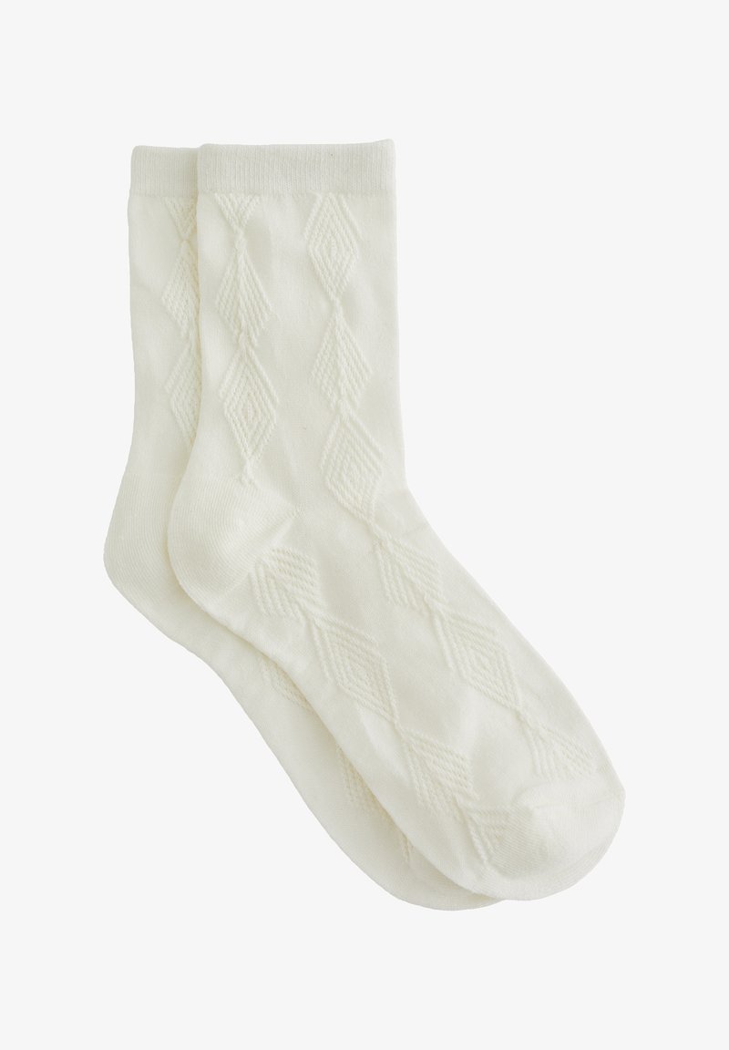 Paire de chaussettes blanches chevilles avec un motif tricoté losange subtil et un bord-côte, présentées à plat et superposées sur fond blanc.