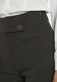 Donkerbruine op maat gemaakte broek met een gladde textuur, slim fit, twee knopen in de taille en een stijlvolle zijzakdetail.