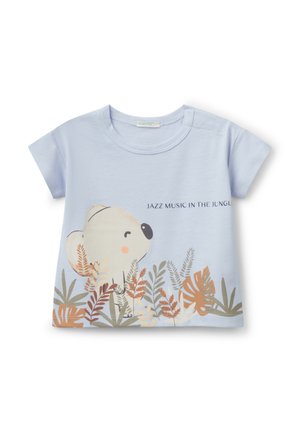 T-shirt in cotone azzurro chiaro con maniche corte. Presenta una grafica di un koala e la scritta "MUSICA JAZZ NELLA GIUNGLA," circondata da motivi di foglie.