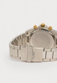 Silberner Edelstahl-Uhr mit gebürsteter Oberfläche, goldenen Akzenten an der Krone und Gliederarmband. Wasserdicht bis 5 ATM.