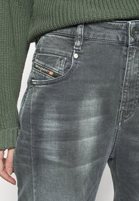 Grå denimjeans med slim fit, med en medelhög midja, subtil blekning och en märkesetikett på framlappen.