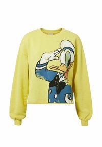 Keltainen lyhyt collegepaita, jossa suuri piirroskuva sarjakuvamaisesta ankan hahmosta tervehdyksessä, sinisillä yksityiskohdilla ja mustalla rusetilla, pehmeä kangaspinta.