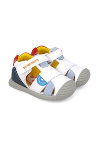 Sandali per bambini bianchi e blu con cinturini in velcro, suole grigie e accenti interni colorati. Presentano lati aperti e un design di supporto.