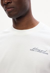 Bílý bavlněný tričko s kulatým výstřihem, krátkými rukávy a modrým výšivkovým nápisem "fishing good MARC O POLO DENIM."